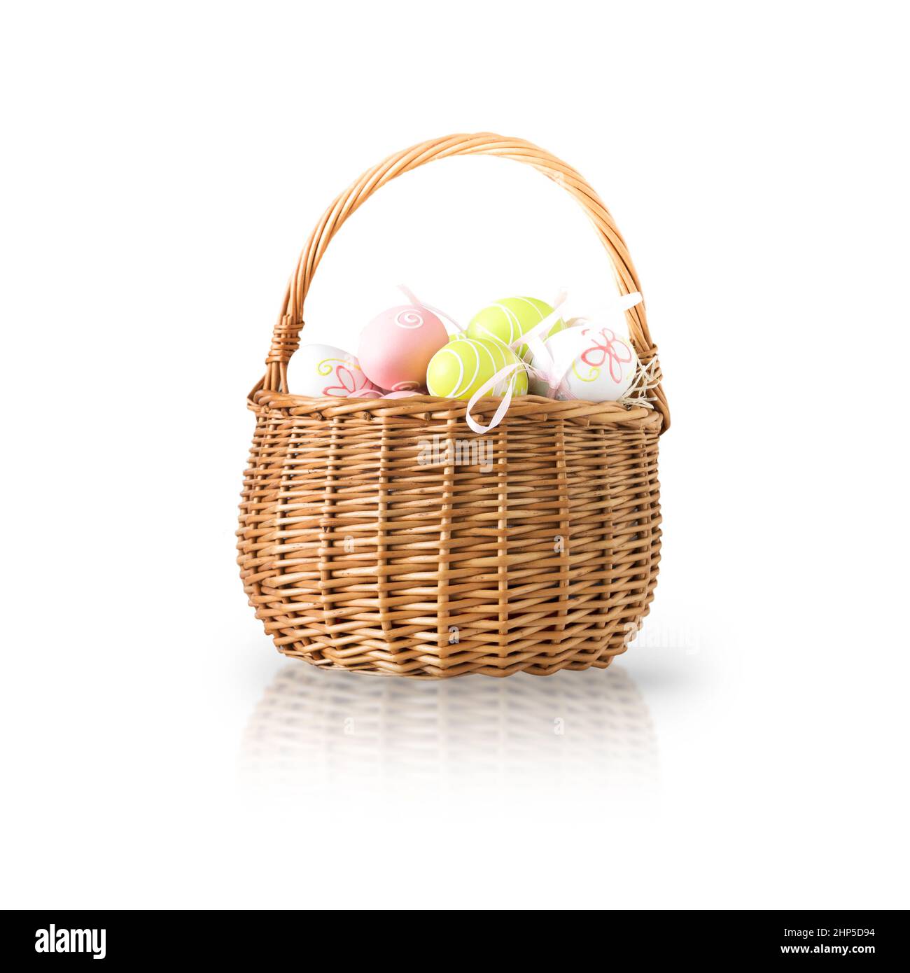 Wicker basket with easter colorful eggs isolated on white background. Spring easter composition. Stock Photo