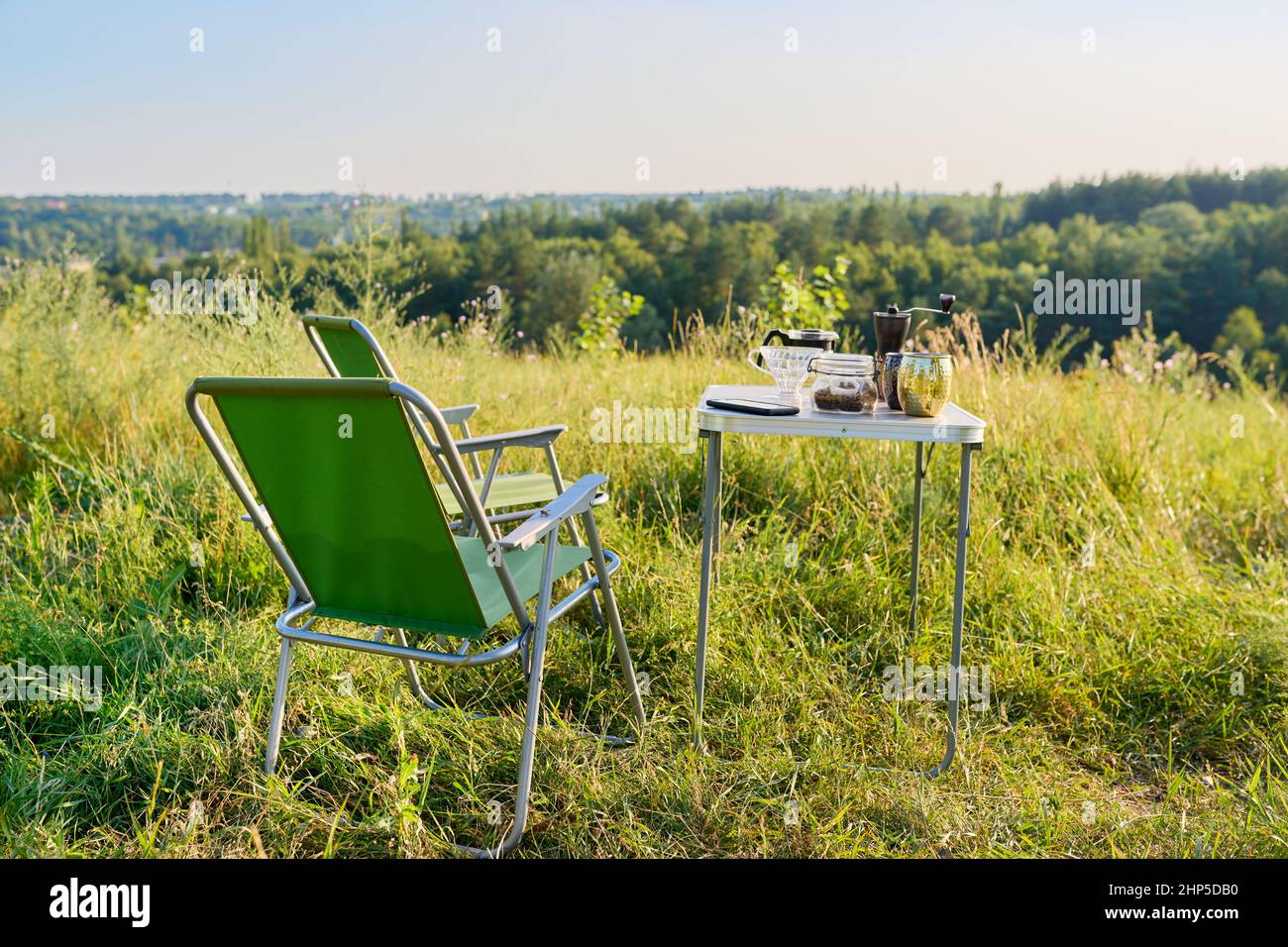 Set of folding furniture for camping, table and chair, summer nature of wild meadow Stock Photo