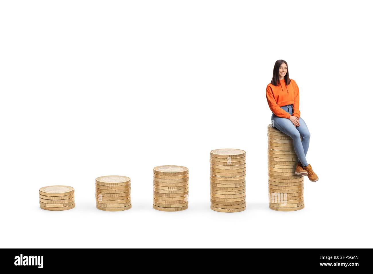 Young female sitting on a pile of coins and looking at camera isolated on white background Stock Photo