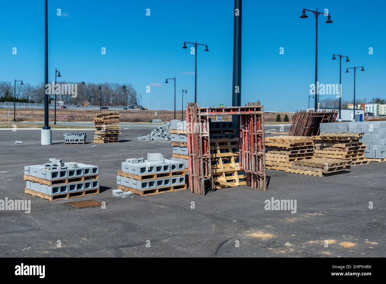 Horizontal shot of cinder blocks, scaffolding, and wooden pallets at an industrial construction site. Stock Photo