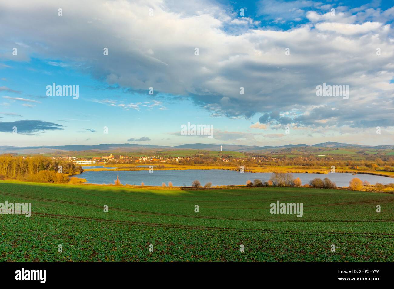 Beautiful view of greenfield near a lake in Werratal, Breitungen under a cloudy sky Stock Photo