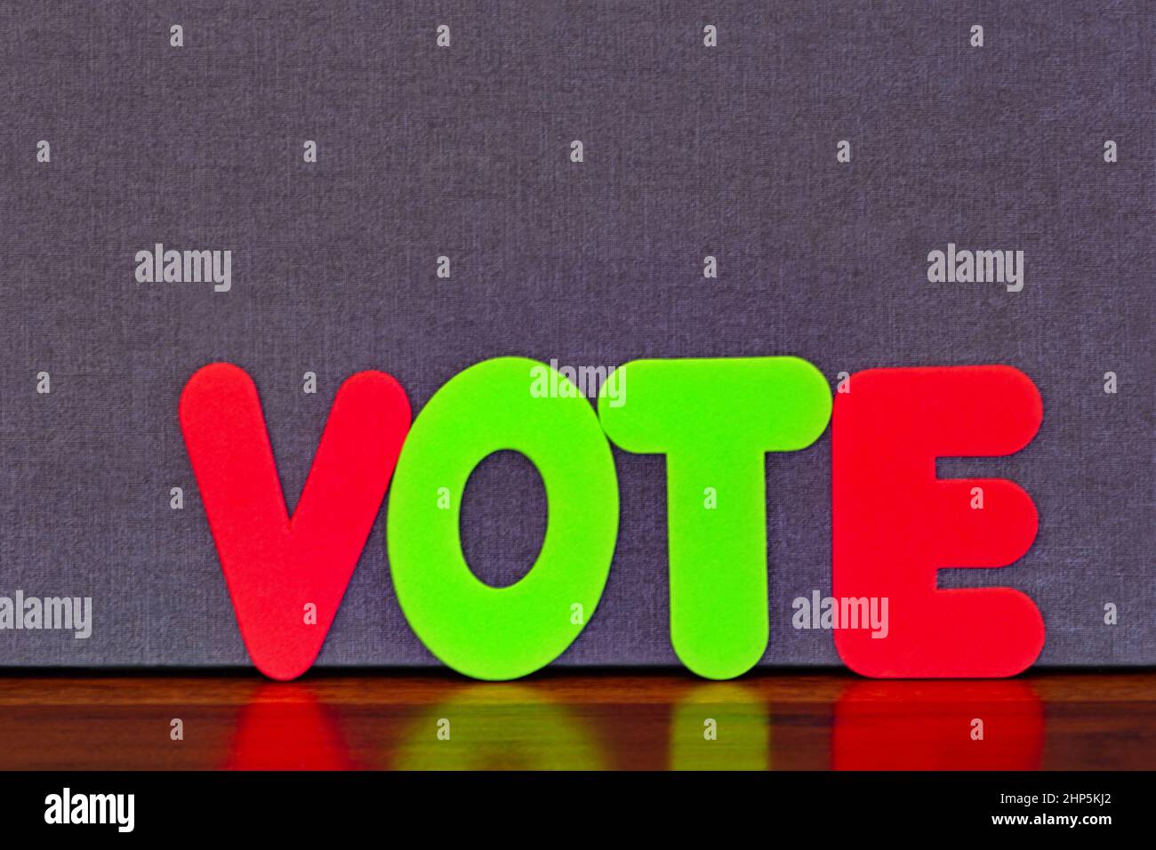 Concept image indicates VOTE in colored letters placed on wood against background with copy space Stock Photo