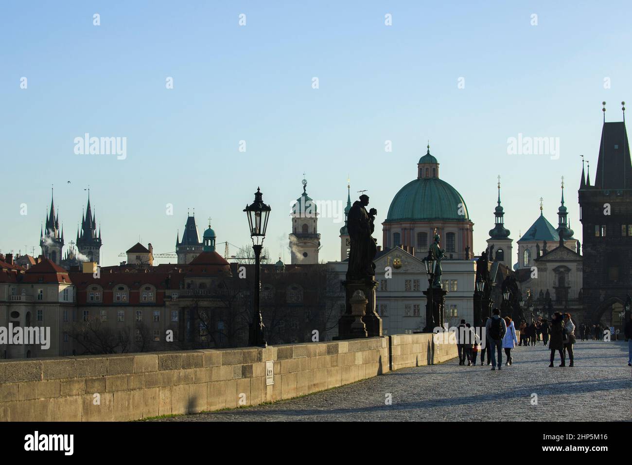 Tourists on the Charles Bridge, in late afternoon sunshine, Prague, Czech Republic, with the spires and domes of the city Stock Photo