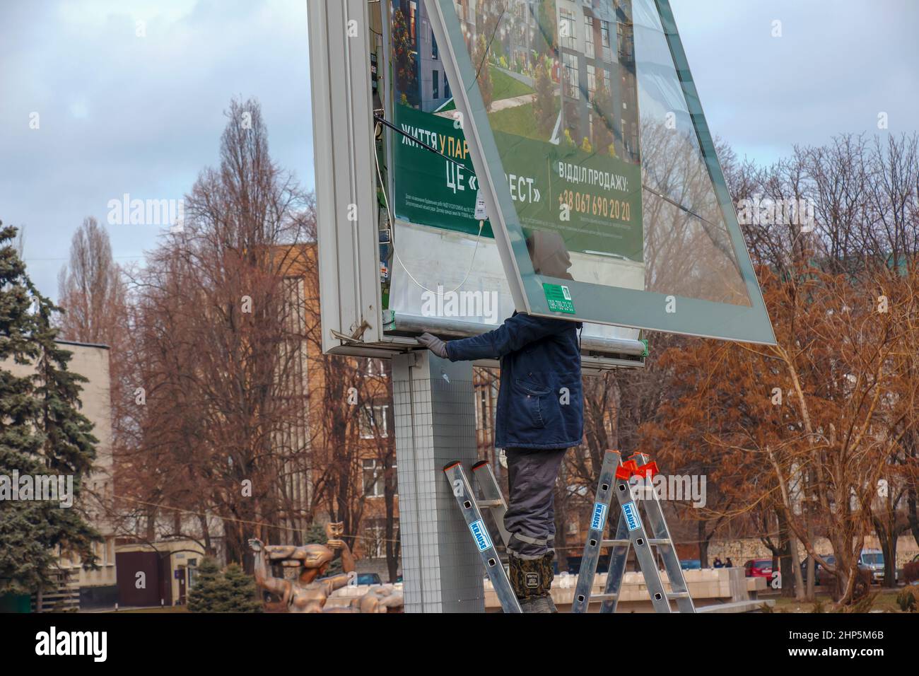 Dnepropetrovsk, Ukraine - 02.09.2022: Installation of outdoor advertising in the city. Specialists climb the stairs to the billboard. Risky job. Work Stock Photo