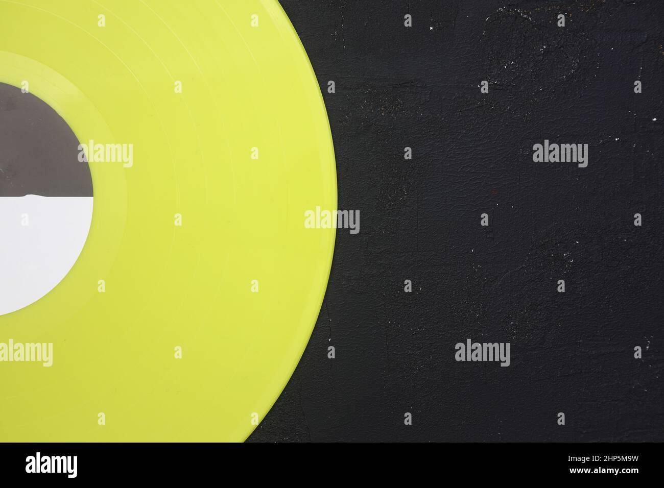 yellow Vinyl record on a black stone background. Retro style. Top view