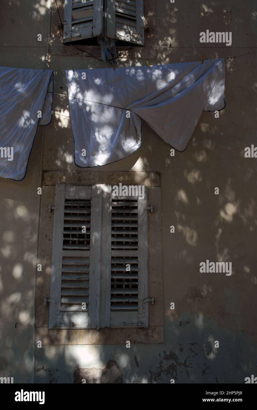 Sheets hanging on washing line from a window, Perast, Montenegro. Stock Photo