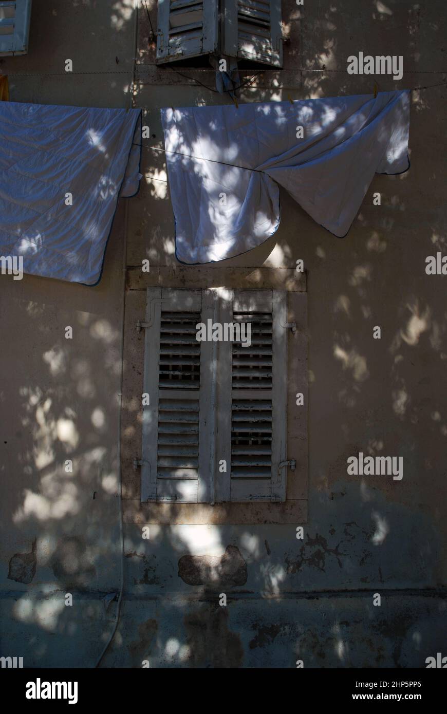 Sheets hanging on washing line from a window, Perast, Montenegro. Stock Photo