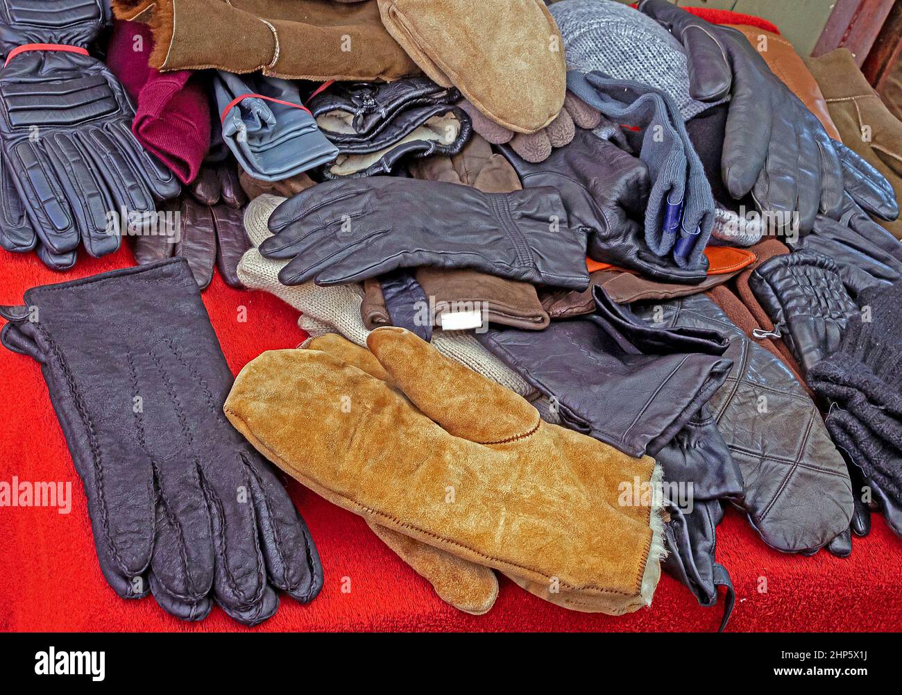 Pile of leather and wool gloves sold on outdoors market during winter period Stock Photo