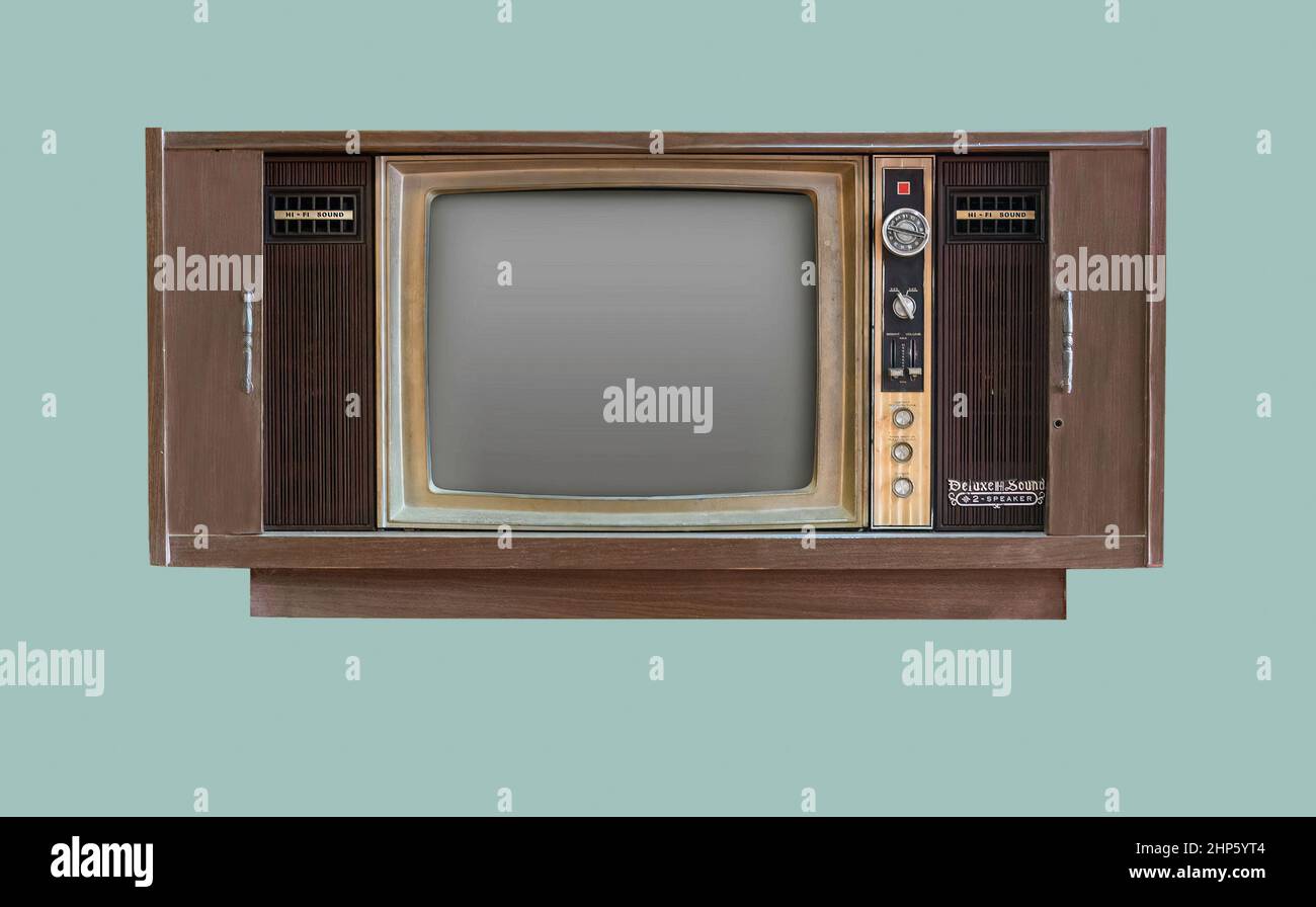 Vintage TV. Old retro TV set in wooden cabinet on isolated green background with clipping path. Stock Photo