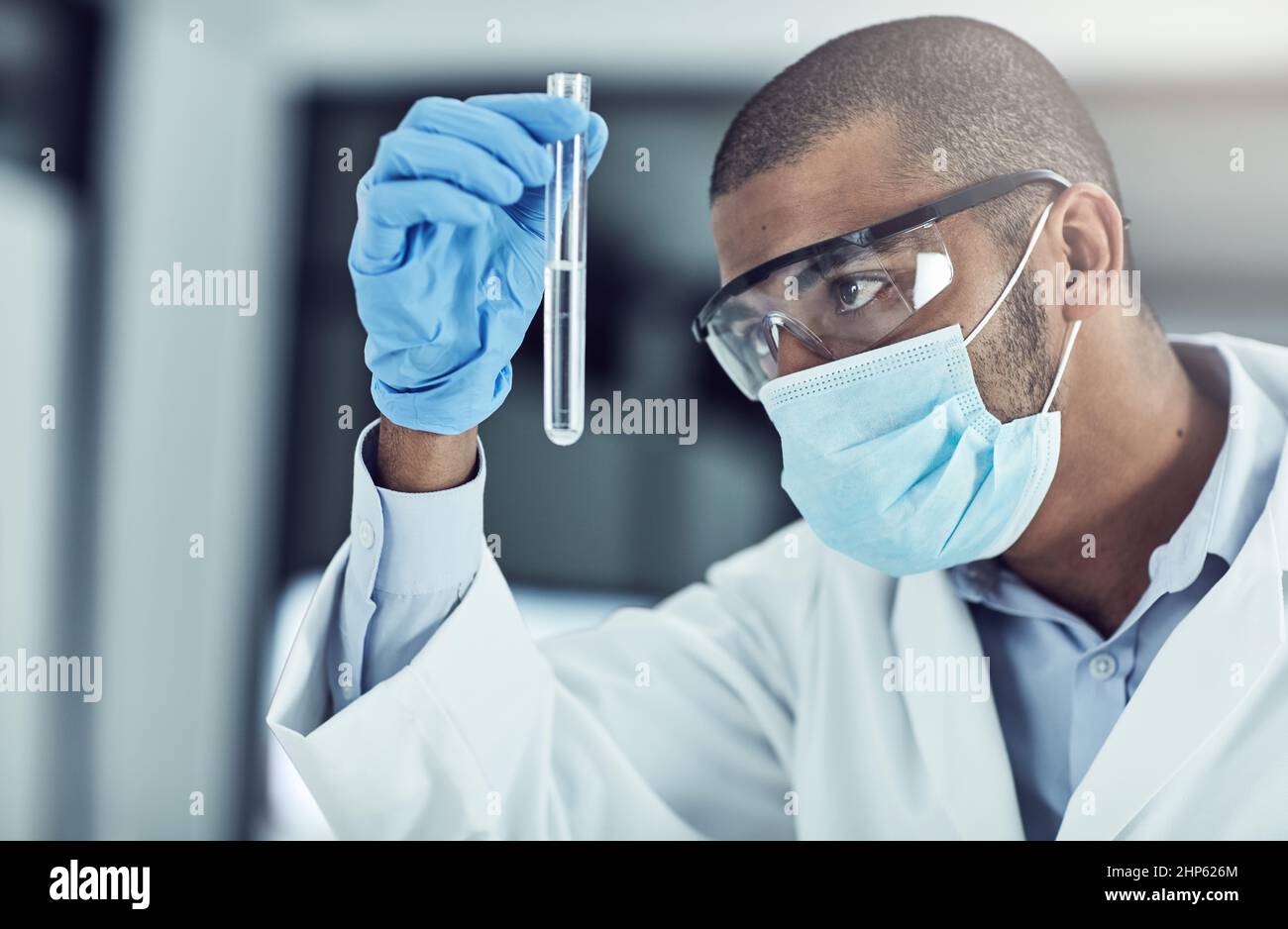 The mysteries of the physical and chemical world intrigue me. Shot of a young scientist conducting an experiment in his lab. Stock Photo