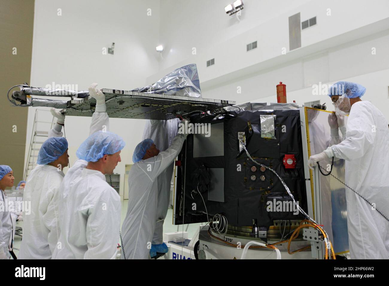 Technicians attach a solar array with its associated science boom to the Radiation Belt Storm Probe B at the Astrotech facility in Titusville, Fla ca. 2012 Stock Photo