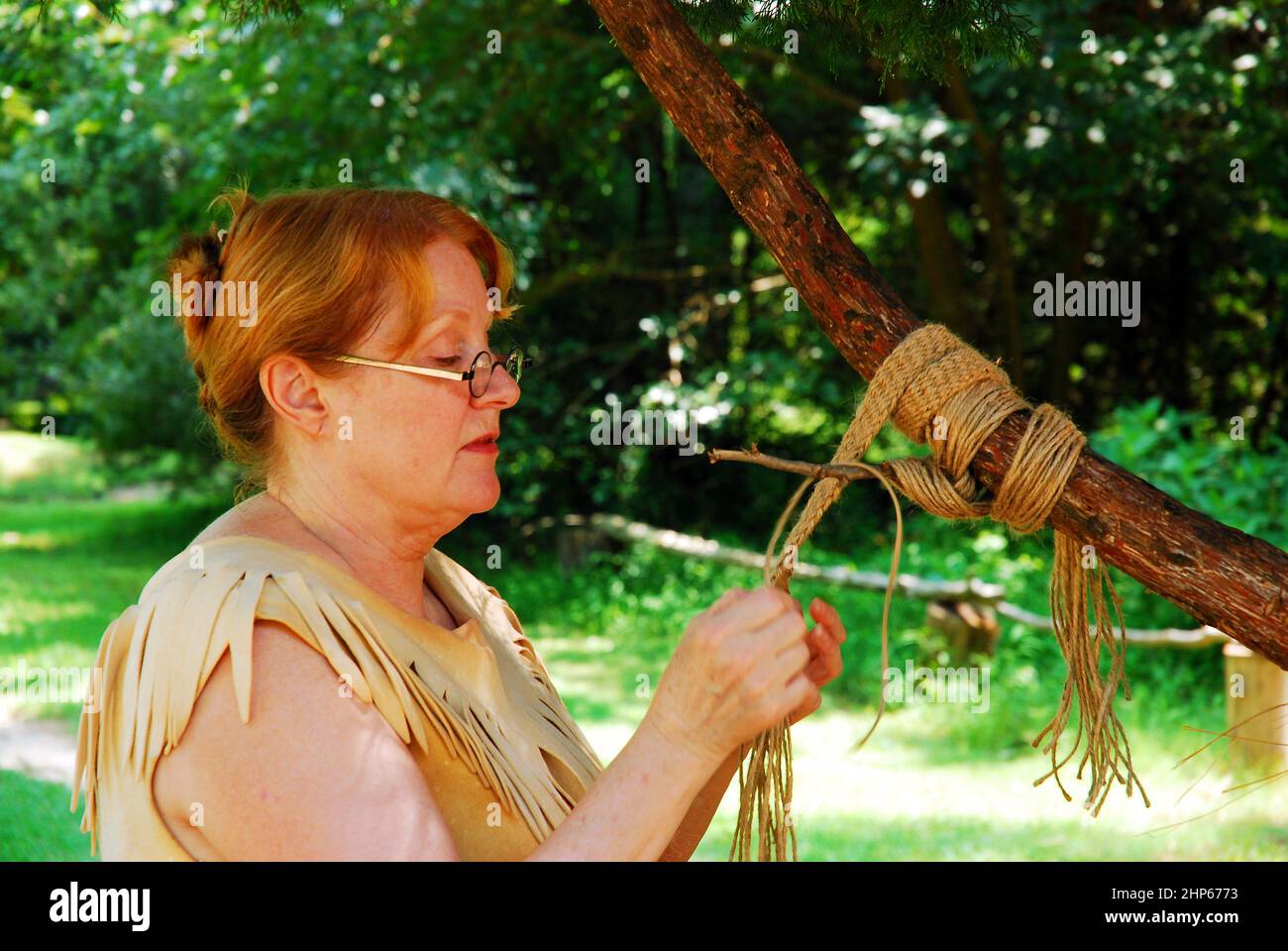 An adult woman demonstrates the traditional Powhatan craft of rope making Stock Photo