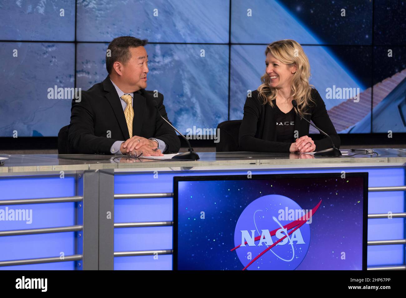 In the Press Site auditorium of NASA's Kennedy Space Center in Florida, from left, Ven Feng, manager of the Transportation Integration Office for the International Space Station Program, and Jessica Jensen, SpaceX director of Dragon Mission Management, speak to media at a post-launch news conference following the liftoff of SpaceX CRS-13. The flight is a commercial resupply services mission to the International Space Station. SpaceX CRS-13 lifted off atop a Falcon 9 rocket from Space Launch Complex 40 at Cape Canaveral Air Force Station at 10:36 a.m. EST with supplies and equipment and new sci Stock Photo