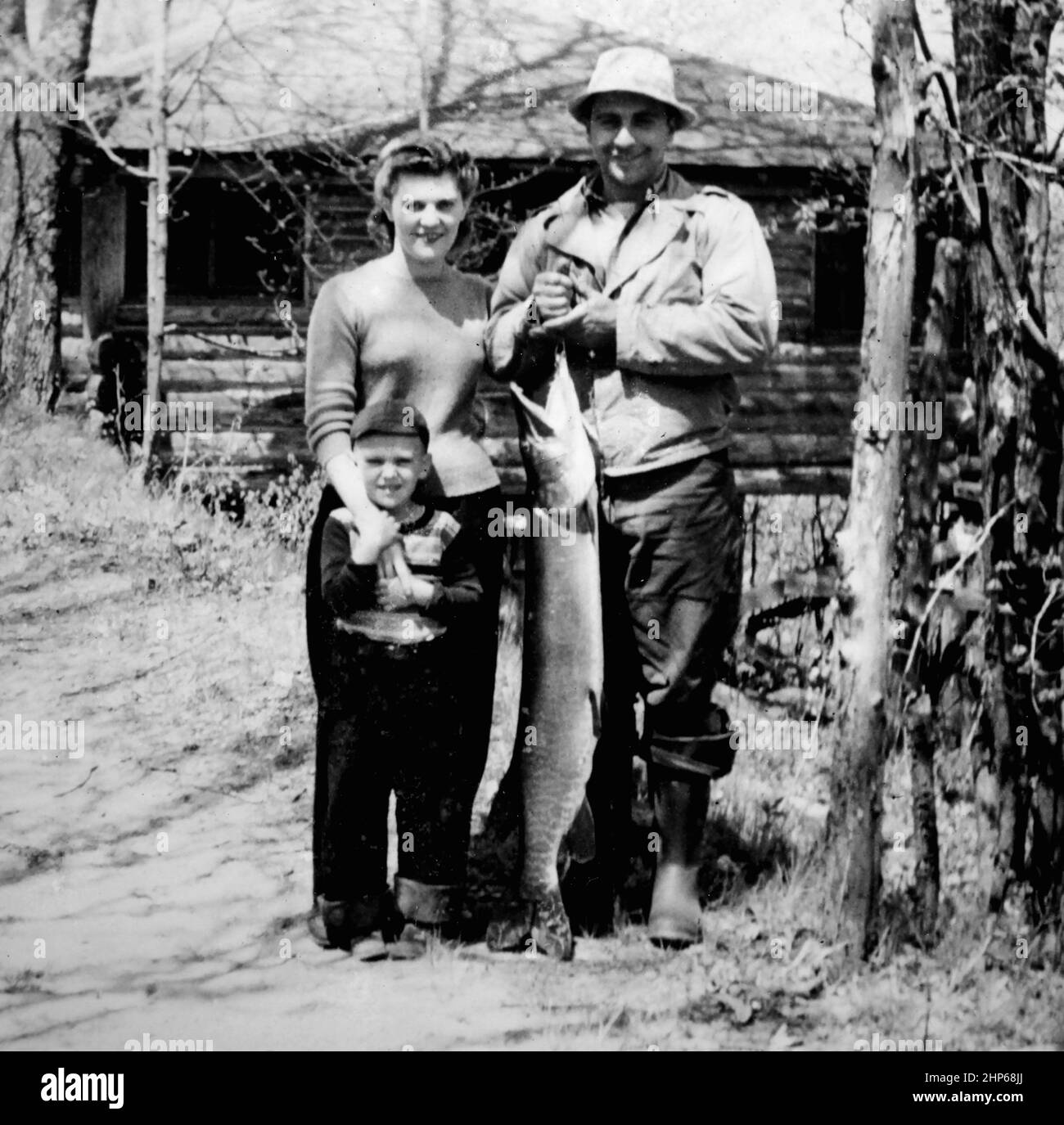 Dad holds a very large Musky while posing with mom and their son in Wisconsin, ca. 1950. Stock Photo