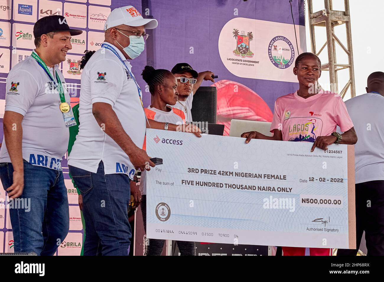 Female marathon winner receives prize money after competing in the Access Bank Lagos City Marathon, on February 12, 2022. Stock Photo