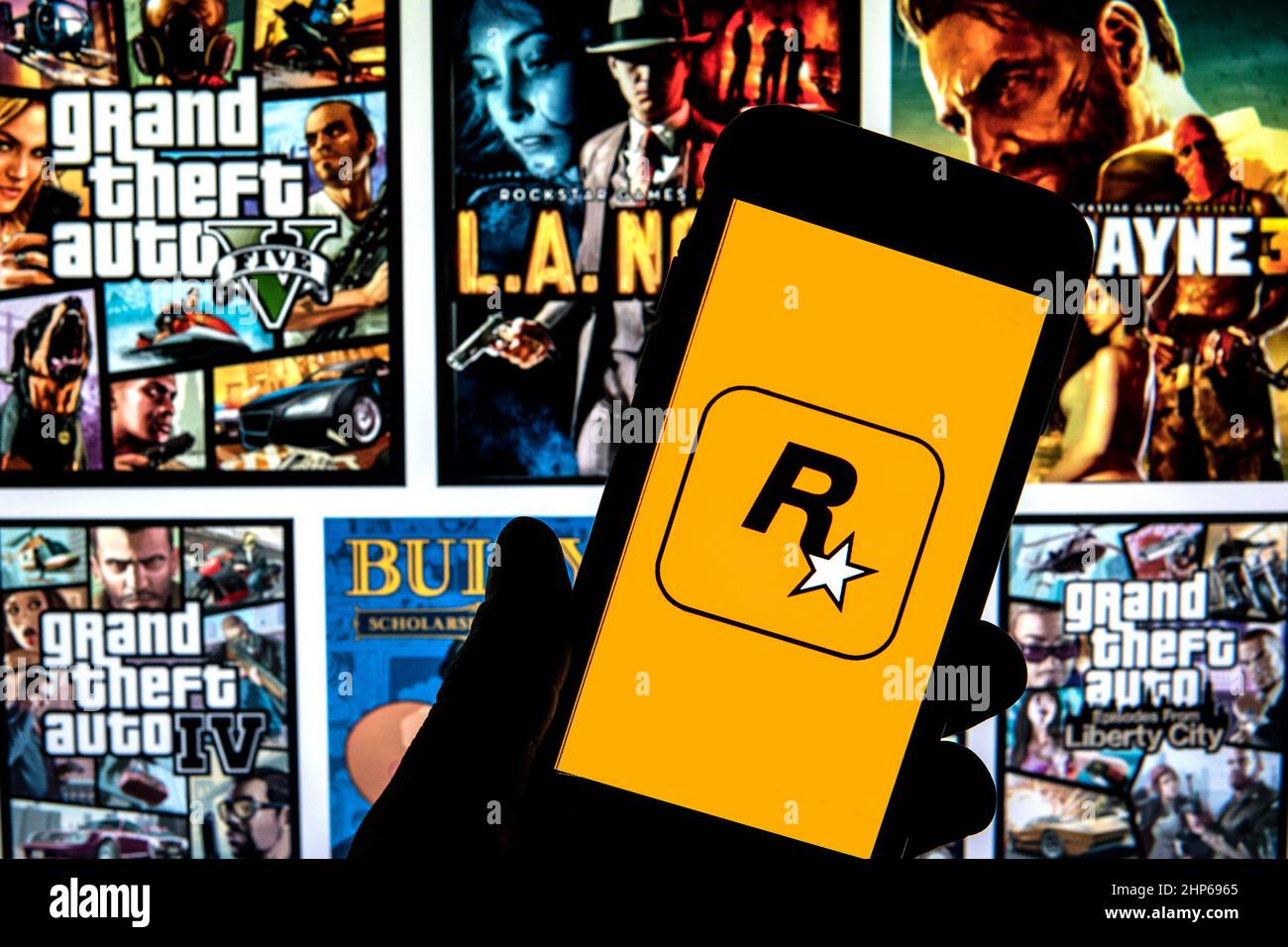 Spain. 17th Feb, 2022. In this photo illustration a Rockstar Games logo seen displayed on a smartphone with video games cover in the background. Credit: SOPA Images Limited/Alamy Live News Stock Photo