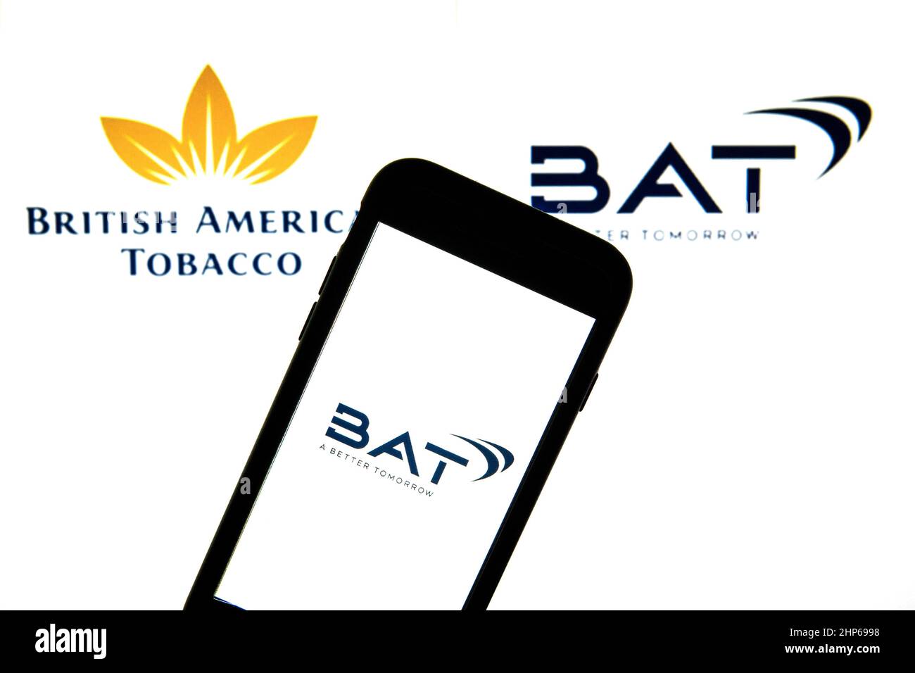 Spain. 17th Feb, 2022. In this photo illustration a British American Tobacco  new logo seen displayed on a smartphone with a British American Tobacco old  and new logo in the background. (Photo