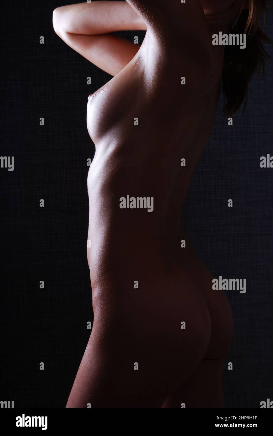 Silhouette of a naked slim woman on a dark background Stock Photo