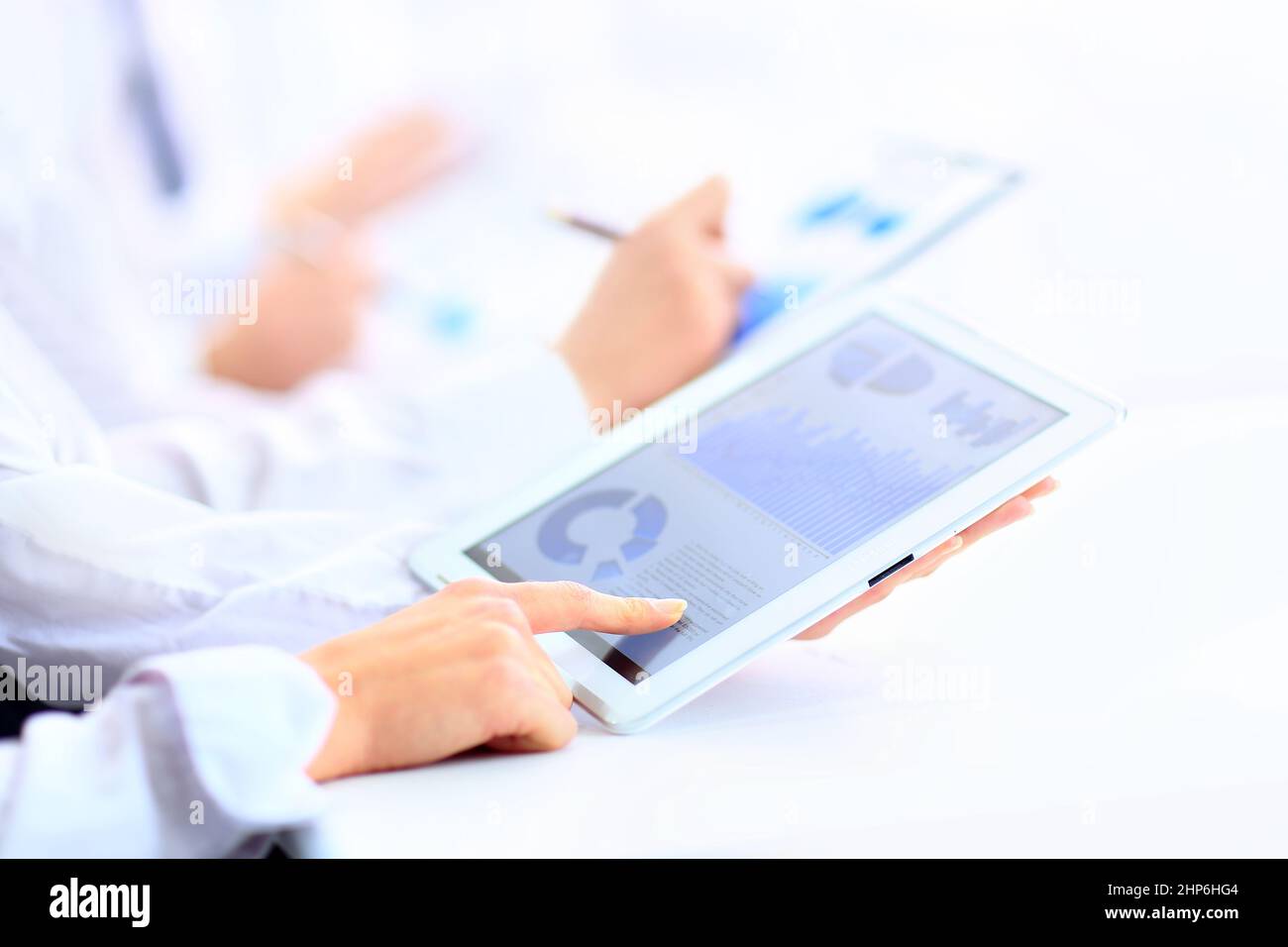 Image of human hand pointing at touchscreen with business document ...