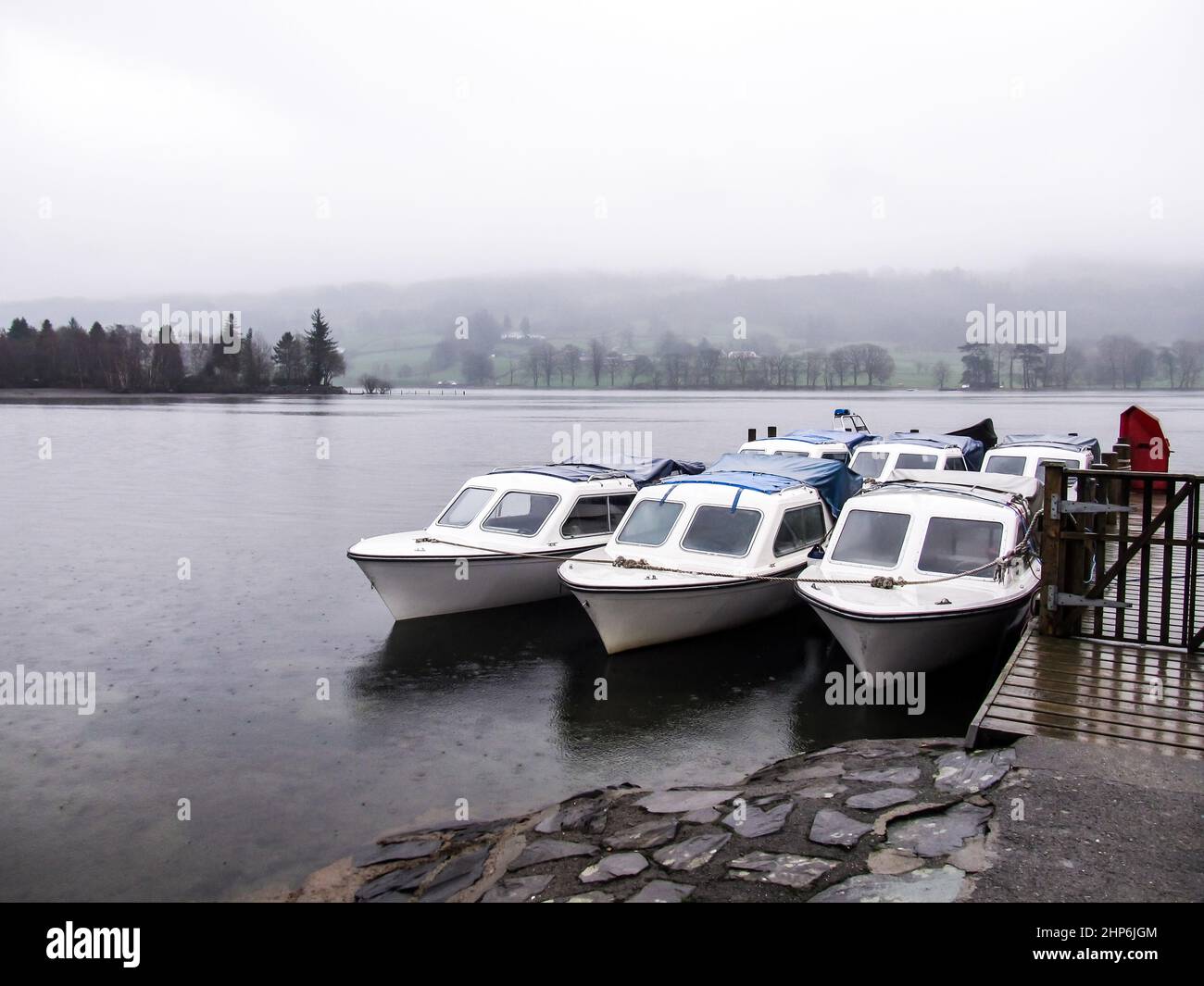 Moored Motorboats on Coniston Water, UK, on a misty and Rainy day Stock Photo