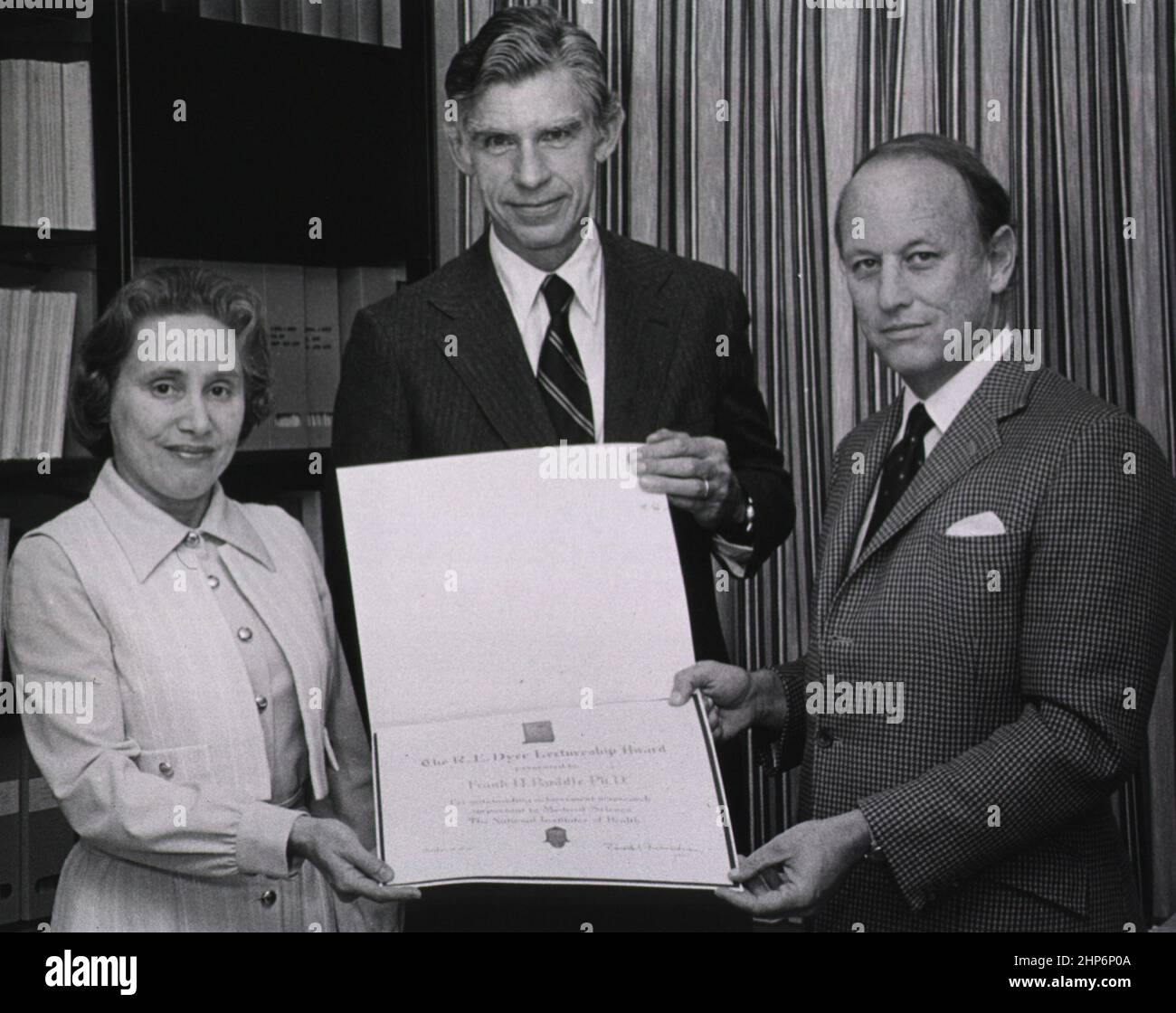 Frank Ruddle, Ph. D., a Yale University professor, is standing between Drs. Ruth Kirschstein, director of the National Institute of General Medical Sciences (NIGMS) and Donald S. Fredrickson, director of the National Institutes of Health (NIH). They are holding the R.E. Dyer lectureship award ca.  1978 Stock Photo