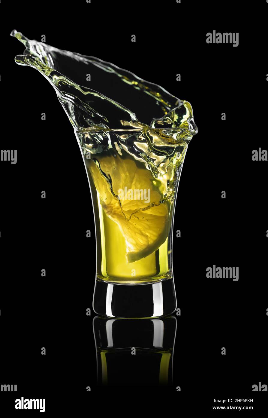 gold tequila shot with lime slice and splash Stock Photo Alamy
