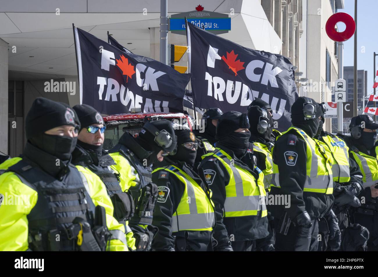 Police officers stand in front of f*ck Trudeau flags while clearing Freedom Convoy protestors out of the area in Ottawa on February 18, 2022. Stock Photo