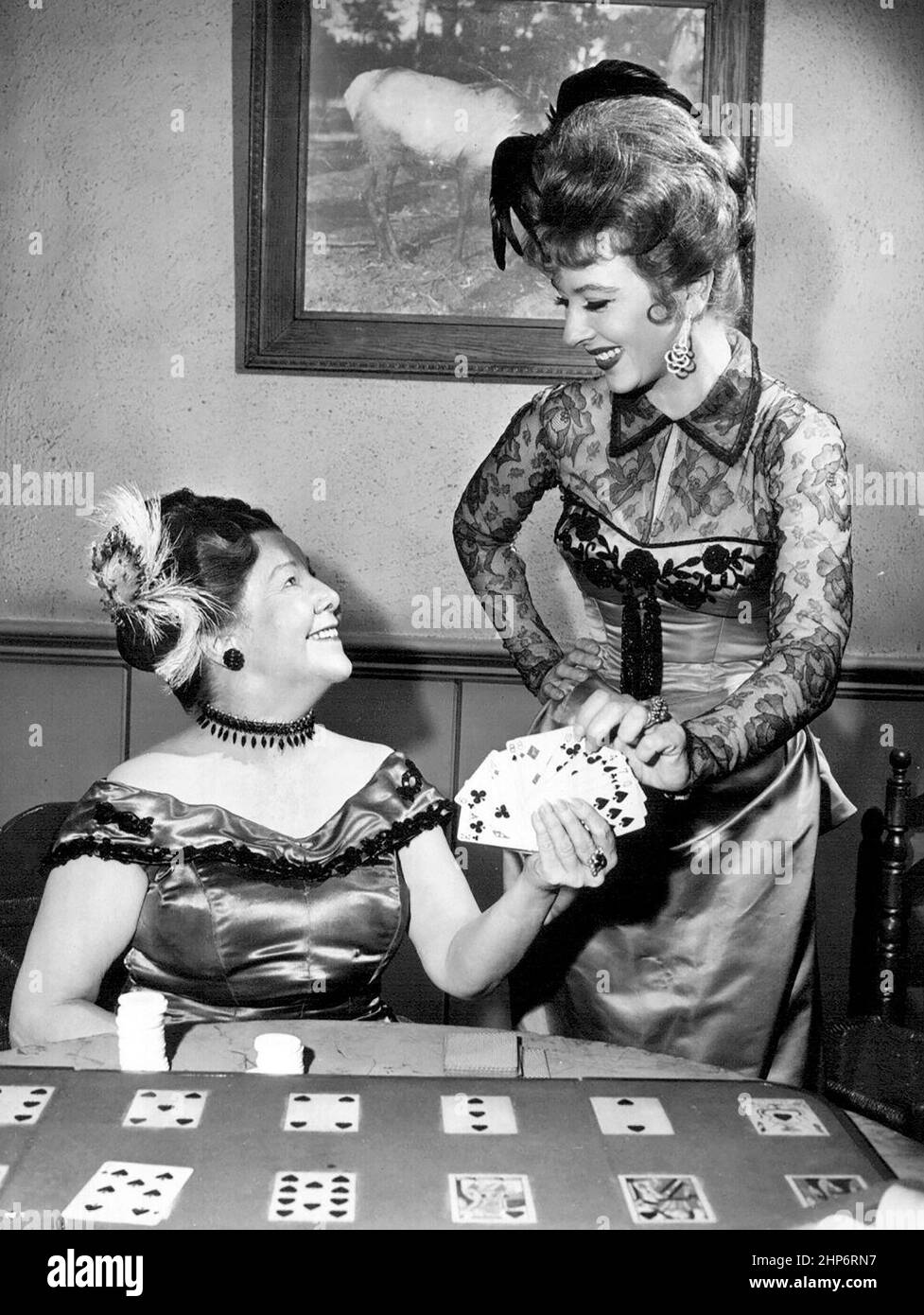 Photo from the television series Gunsmoke.  Pictured playing cards at the Longbranch are Nellie Burt and Amanda Blake as Miss Kitty Russell Stock Photo