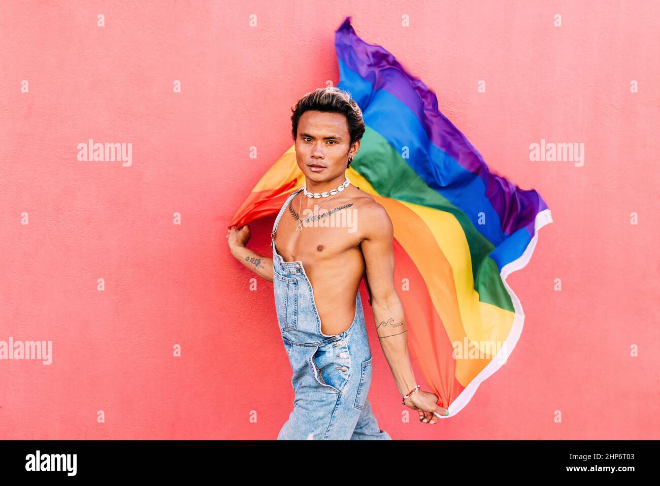 Portrait of a handsome young man holding pride movement LGBT rainbow ...