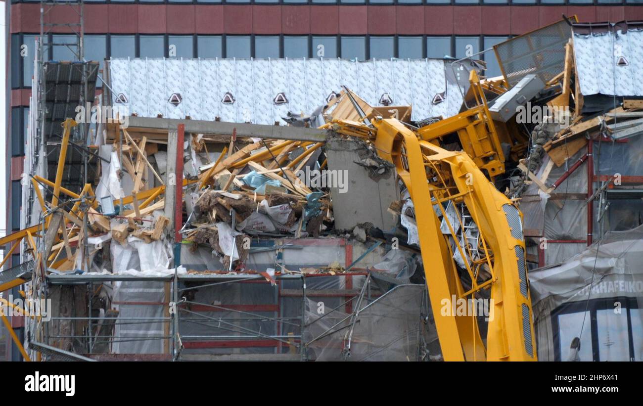 Bremen, Germany. 19th Feb, 2022. A crane lies on top of a building. A 55 meter high construction crane crashed onto the shell of an office building. No one was injured. Credit: Jörn Hüneke/dpa/Alamy Live News Stock Photo