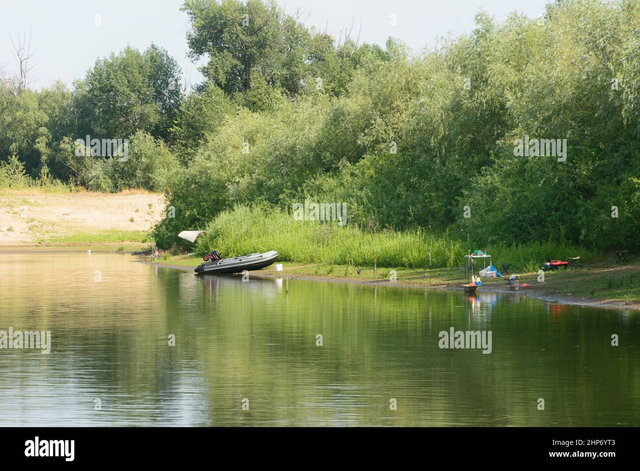 Rubber inflatable boat with motor on the river. Summer fishing. Stock Photo