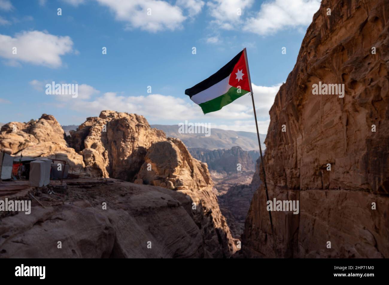 Black, white, green and red flag of Jordan flying over the tourist destination of Petra Stock Photo