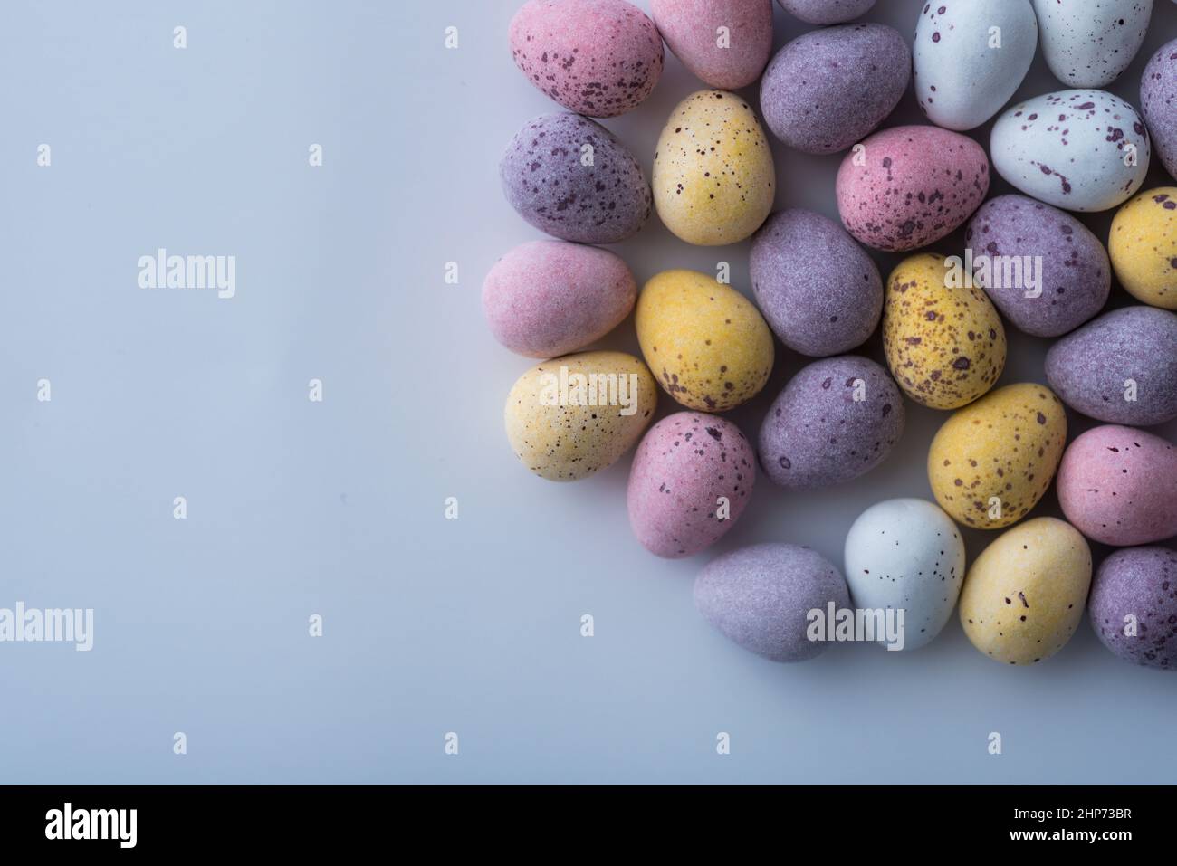 Colorful speckled mini Easter eggs on a plain back ground shot from above, flat lay Stock Photo
