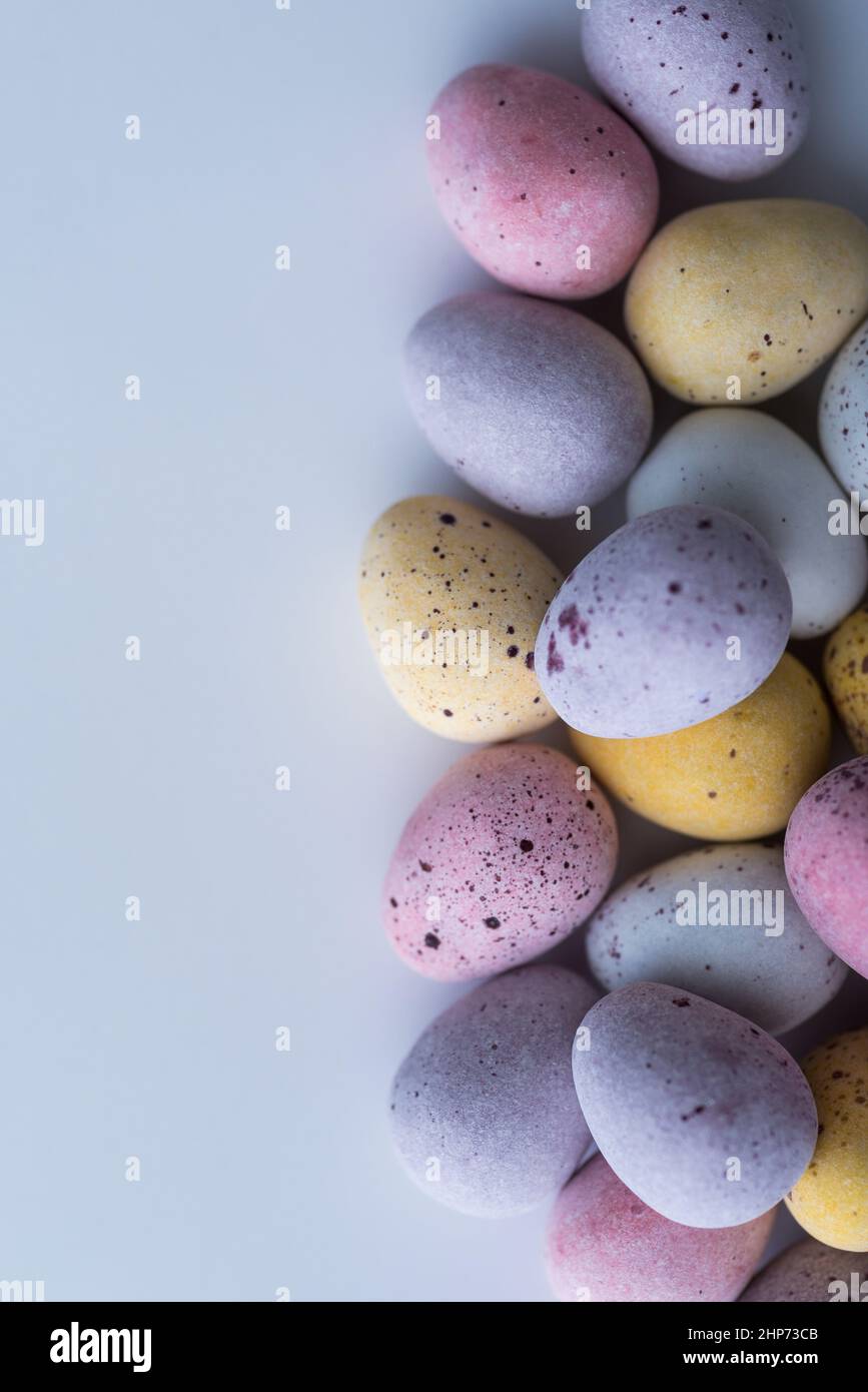 Colorful speckled mini Easter eggs on a plain back ground shot from above, flat lay Stock Photo