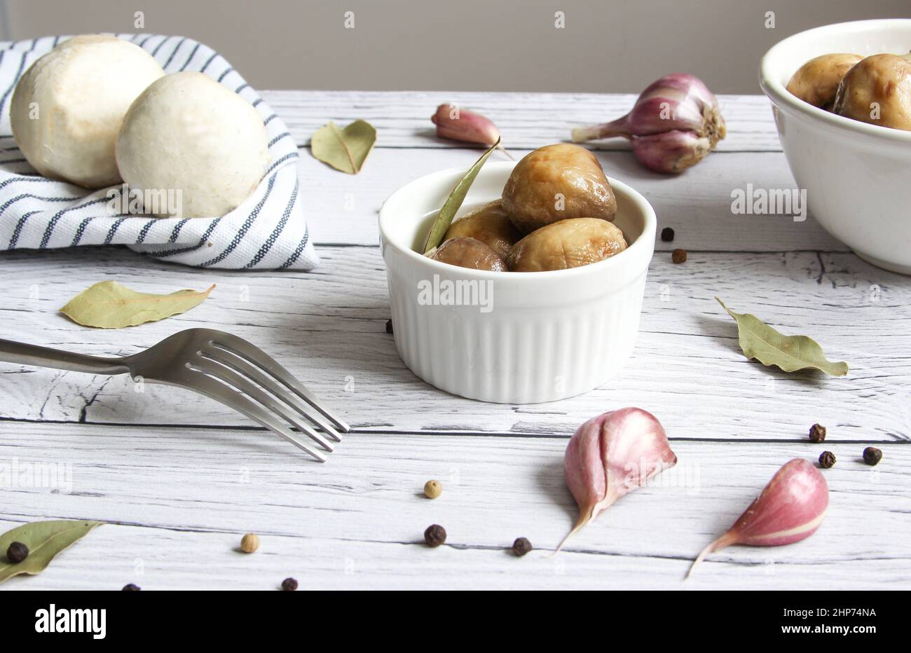 Marinated mushrooms with garlic, black pepper and bay leaf. Champignon