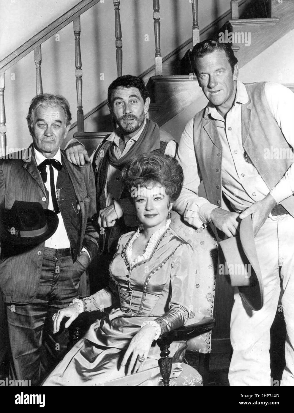 Main cast photo from the television program Gunsmoke in 1967.  Standing, from right: James Arness as Marshall Matt Dillon, Ken Curtis as Festus Hagen, and Milburn Stone as 'Doc' Adams. Seated: Amanda Blake as 'Miss Kitty' Russell Stock Photo