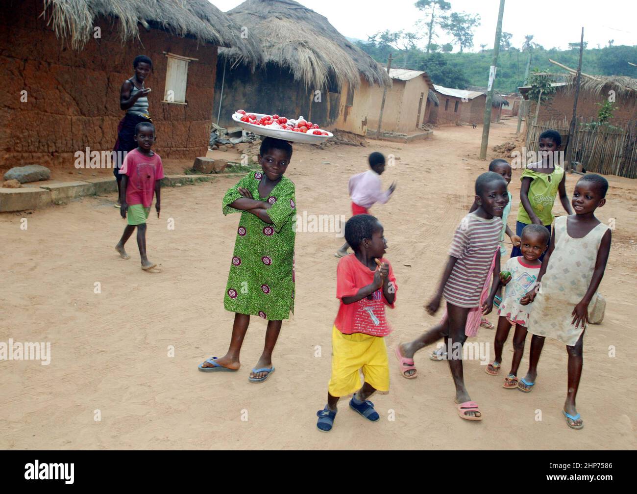 Children in Ghana in Village.Child carrying tray on head. West Africa Stock Photo