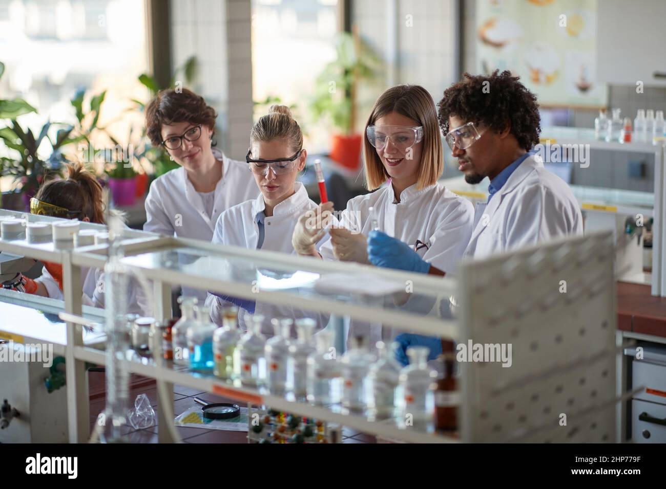 Young students enjoy working with chemicals in a sterile laboratory environment. Science, chemistry, lab, people Stock Photo