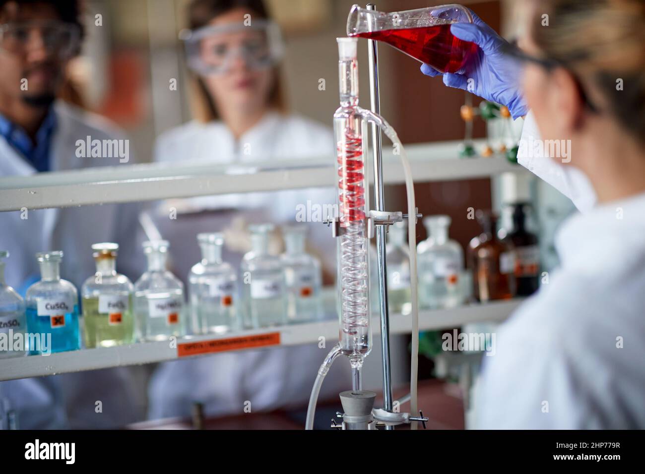 Young chemistry students are working with chemical apparatus in a laboratory in a working atmosphere. Science, chemistry, lab, people Stock Photo