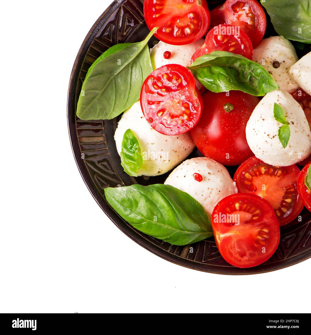 Round camembert cheese with cherry tomatoes and basil on plate. Stock Photo