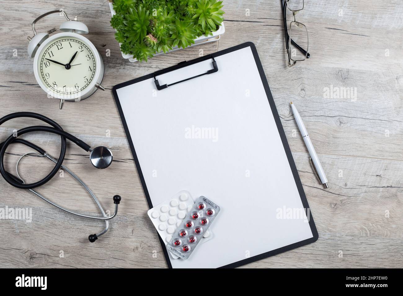 Treatment plan for a patient, doctor's desk top view. Stethoscope, note pad and alarm clock. medical concept Stock Photo