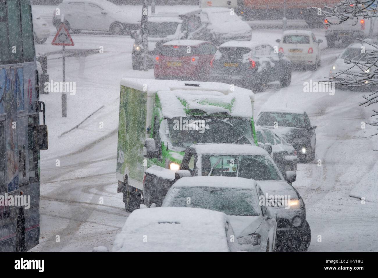 Snow and ice causing disruption on the hills around Bradford, West Yorkshire, UK. 19th Feb 2022. Cars struggle to move on slippery winter surfaces. Stock Photo