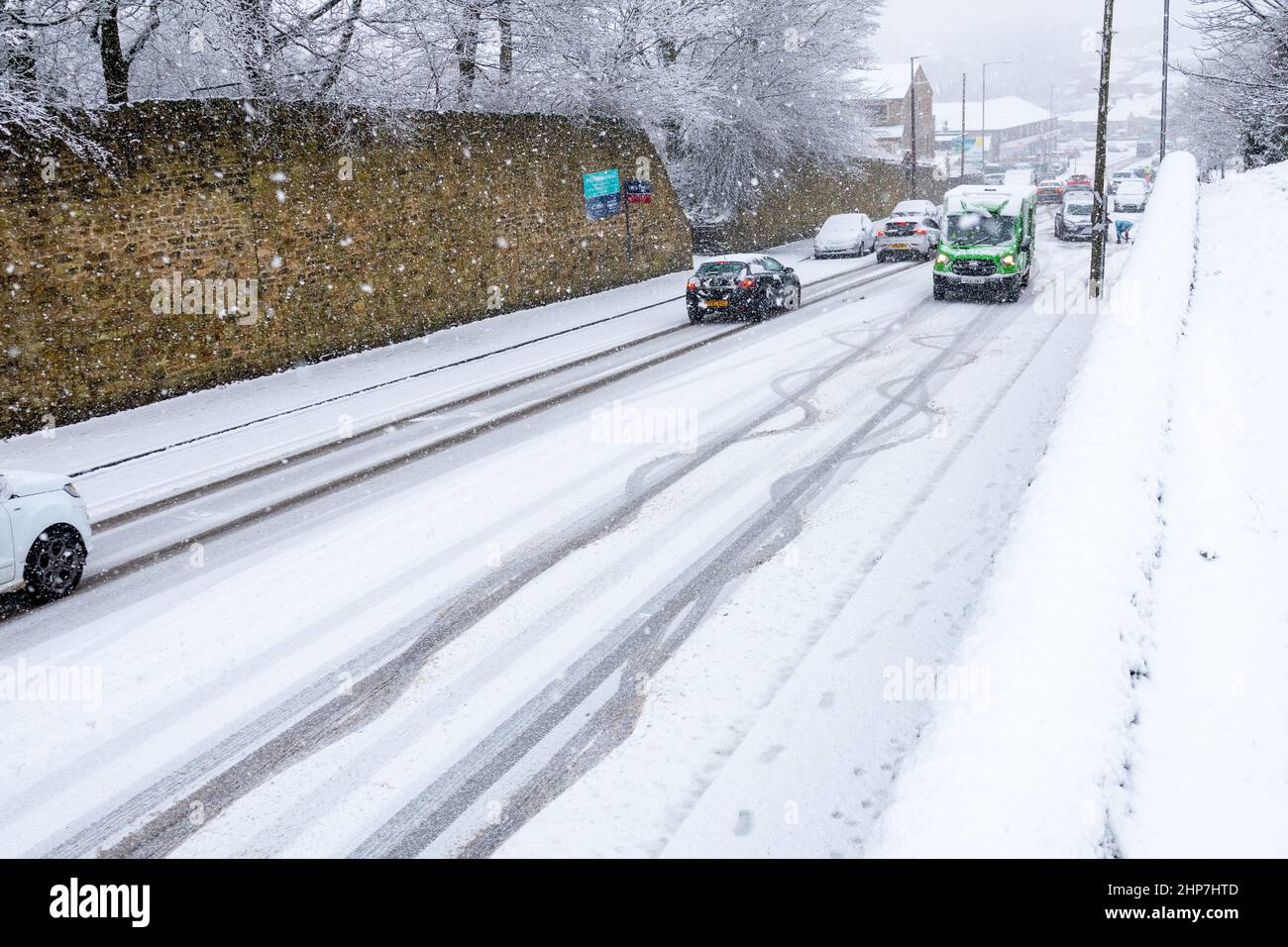 Snow and ice causing disruption on the hills around Bradford, West Yorkshire, UK. 19th Feb 2022. Cars struggle to move on slippery winter surfaces. Stock Photo