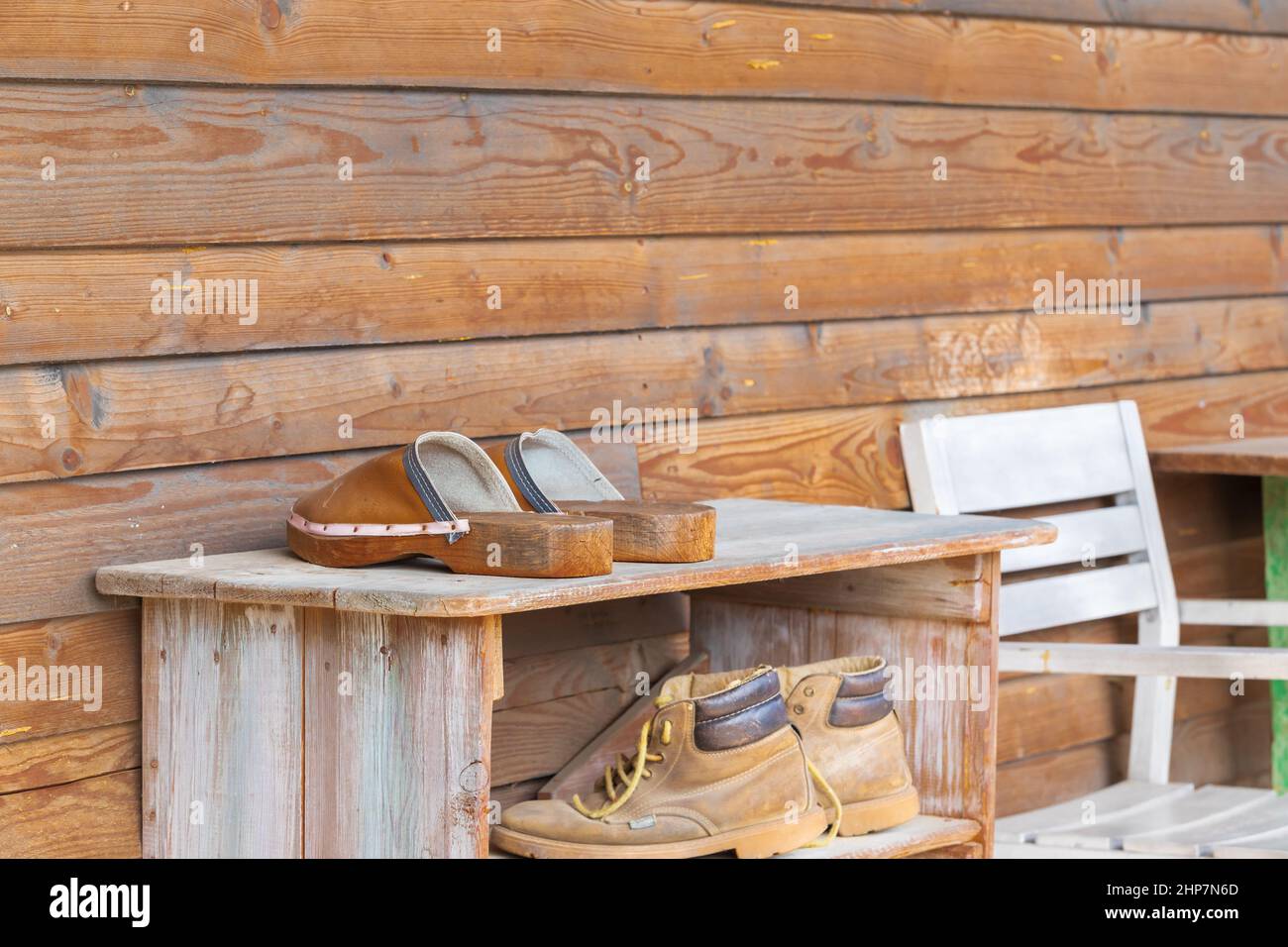 https://c8.alamy.com/comp/2HP7N6D/old-wooden-shoebox-near-a-wooden-cottage-on-a-farm-the-shoe-box-has-old-clogs-rubber-boots-and-shoes-2HP7N6D.jpg