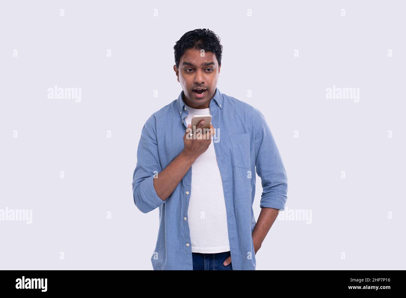 Indian Man Talking on Phone Standing Isolated. Angry Man Loudly speaking on Phone Commecial, Shopping, Advertisment Concept. Technology Stock Photo