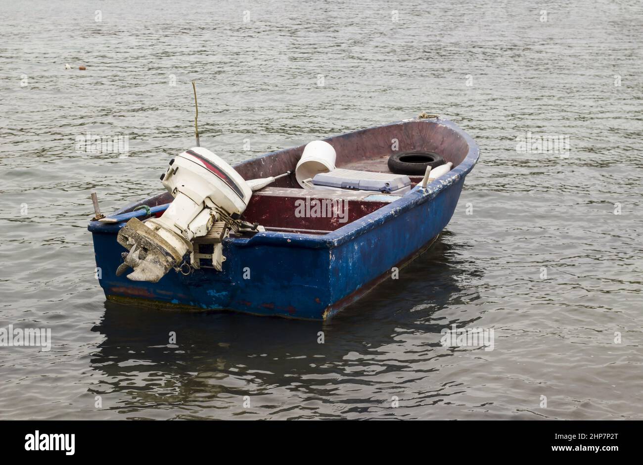 Empty and old fishing boat with engine moored on the blue sea Stock Photo -  Alamy