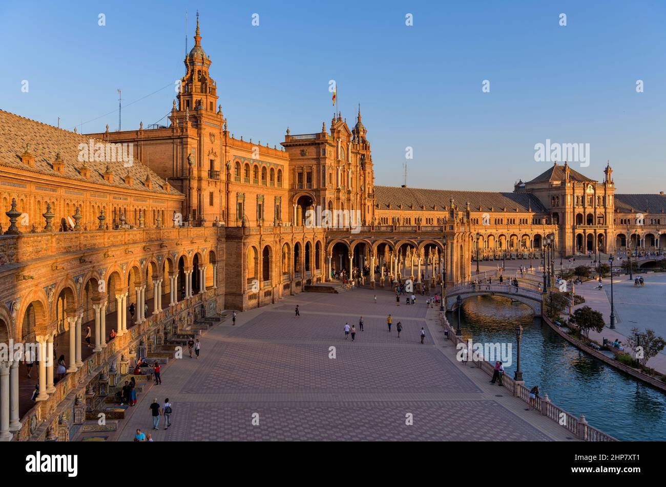 Sunset Spanish Square - A golden autumn sunset view of the brick and tile buildings, bridges and canal of Spanish Square, Seville, Andalusia, Spain. Stock Photo