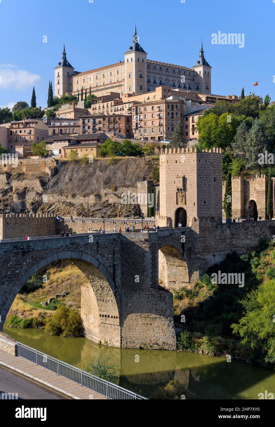 Toledo Spain - Vertical morning view of historic city Toledo at Puente de Alcántara, with Alcázar fortress standing tall at hilltop. Toledo, Spain. Stock Photo