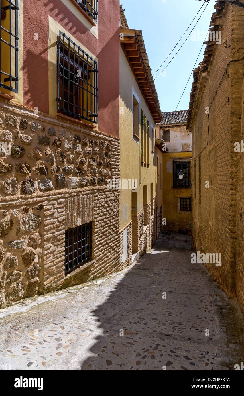 Old Town Alley - A wide-angle vertical view of a narrow and steep alleyway in the historic city Toledo on a sunny Autumn afternoon. Toledo, Spain. Stock Photo