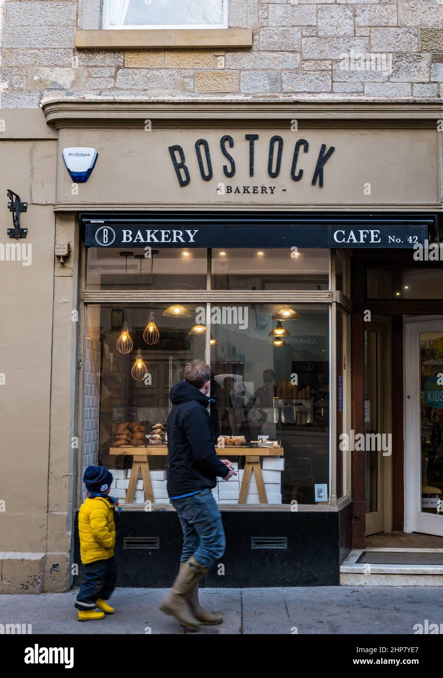 Bostock Bakery shop front with man and child walking past looking at pastries, High Street, North Berwick, Scotland, UK Stock Photo